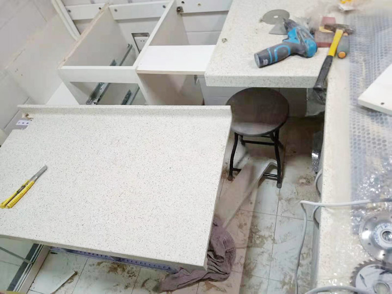 櫥柜維修改造：對廚房作防護(hù)措施,掛擋布、廚房墻面等做簡單清理,以便準(zhǔn)確測量地面水平。 材料進(jìn)場:櫥柜板材等進(jìn)場。  安裝地柜 組裝:統(tǒng)一組裝好地柜,搬進(jìn)廚房,按圖紙順序擺放好位置(倒放),統(tǒng)一安裝地腳。 現(xiàn)場切割:地面上墊上保護(hù)物,割口根據(jù)實物的大小從反面進(jìn)行操作,保持正面不崩。 安裝順序：如有轉(zhuǎn)角柜應(yīng)先安轉(zhuǎn)角柜，沒有轉(zhuǎn)角柜先從靠墻的柜往外安裝。 水平調(diào)整：通過地柜的調(diào)節(jié)腿調(diào)節(jié)地柜水平度，誤差保持正負(fù)1mm。